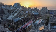 Palestinians gather for a mass fast-breaking iftar meal in front of the destroyed Salim Abu Muslim mosque in Beit Lahia in the northern Gaza Strip on March 15, 2025. (Photo by Omar Al-Qattaa / AFP)