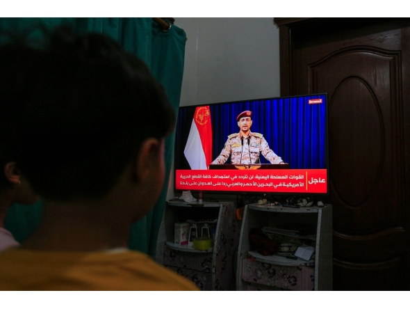 Yemenis in Sanaa watch a televised statement by the Houthi military spokesman Yahya Saree announcing the rebel group launched an attack on a US aircraft carrier in the Red Sea on March 16, 2025. (Photo by Mohammed HUWAIS / AFP)