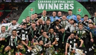 Newcastle United's players celebrate with the trophy on the pitch after the English League Cup final football match between Liverpool and Newcastle United at Wembley Stadium, north-west London on March 16, 2025. Newcastle won the game 2-1. (Photo by Glyn KIRK / AFP) 