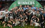 Newcastle United's players celebrate with the trophy on the pitch after the English League Cup final football match between Liverpool and Newcastle United at Wembley Stadium, north-west London on March 16, 2025. Newcastle won the game 2-1. (Photo by Glyn KIRK / AFP) 