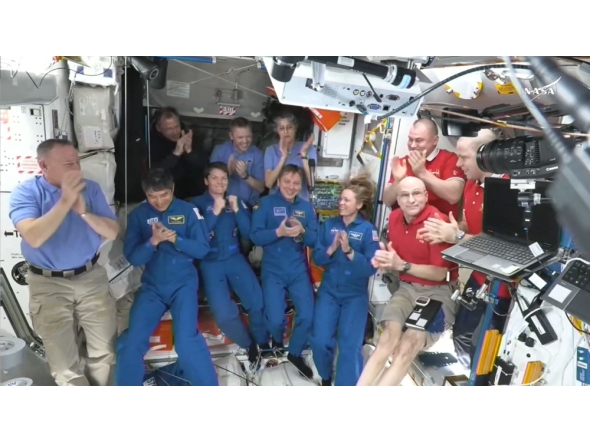 This screengrab made from a NASA livestream shows the SpaceX Dragon Crew-10 members (C, in dark blue) NASA astronauts Anne McClain and Nichole Ayers, JAXA (Japan Aerospace Exploration Agency) astronaut Takuya Onishi, and Roscosmos cosmonaut Kirill Peskov, clapping after entering the International Space Station flanked by NASA astronauts Butch Wilmore, Suni Williams, Nick Hague and Don Pettit and Russian cosmonauts Aleksandr Gorbunov, Alexey Ochinin and Ivan Vagner, on March 16, 2025. (Photo by NASA / AFP)