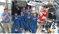 This screengrab made from a NASA livestream shows the SpaceX Dragon Crew-10 members (C, in dark blue) NASA astronauts Anne McClain and Nichole Ayers, JAXA (Japan Aerospace Exploration Agency) astronaut Takuya Onishi, and Roscosmos cosmonaut Kirill Peskov, clapping after entering the International Space Station flanked by NASA astronauts Butch Wilmore, Suni Williams, Nick Hague and Don Pettit and Russian cosmonauts Aleksandr Gorbunov, Alexey Ochinin and Ivan Vagner, on March 16, 2025. Photo by NASA / AFP