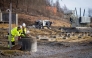 Representatives from a private company assisting with environmental consulting take water samples after several tons of oil leaked out in Baerum near Oslo, Norway, on March 17, 2025 following a break-in and damage to the Hamang transformer station this weekend. Photo by Ole Berg-Rusten / NTB / AFP