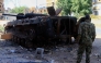 This picture shows a fighter in front of a burnt military vehicle, in Khartoum North, on March 17, 2025. Nearly two years of war between the army and the paramilitary Rapid Support Forces (RSF) have left large swathes of Sudan's capital unrecognisable. (Photo by Ebrahim Hamid / AFP)
