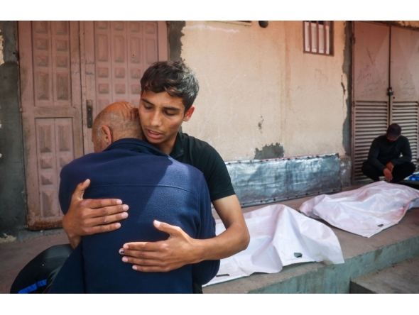 Relatives mourn by the bodies of three Palestinian men killed in an Israeli drone strike east of the Bureij camp, at the al-Aqsa Martyrs hospital in Deir el-Balah in the central Gaza Strip on March 17, 2025. (Photo by Eyad Baba / AFP)