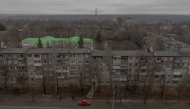 A car drives past residential buildings damaged by air attacks, in Kostyantynivka, eastern Donetsk region, on March 17, 2025, amid the Russian invasion of Ukraine. (Photo by Roman Pilipey / AFP)