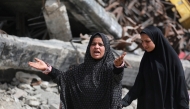 A woman gestures as Palestinians leave Beit Hanun in the northern Gaza Strip with their belongings, heading towards Gaza City following Israeli evacuation orders on March 19, 2025. (Photo by Bashar Taleb / AFP)