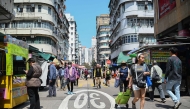 Pedestrians walk along a street in Hong Kong on March 19, 2025. (Photo by Peter PARKS / AFP)