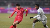 South Korea's Son Heung-min (L) competes for the ball with Oman's Abdullah Al-Harthi (R) during the World Cup 2026 Asian qualifier football match between South Korea and Oman in Goyang on March 20, 2025. (Photo by Jung Yeon-je / AFP)
 