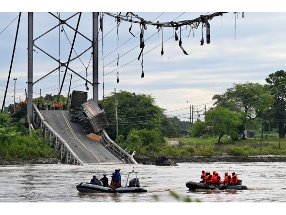 In this aerial view rescuers search for missing persons after a suspension bridge collapsed in Duale, Guayas province, Ecuador on March 20, 2025. The collapse in Ecuador of a busy 200-metre-long suspension bridge carrying several vehicles left at least one dead, five injured and two missing, authorities said in a new assessment on Thursday. (Photo by MARCOS PIN / AFP)
