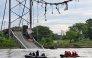 In this aerial view rescuers search for missing persons after a suspension bridge collapsed in Duale, Guayas province, Ecuador on March 20, 2025. The collapse in Ecuador of a busy 200-metre-long suspension bridge carrying several vehicles left at least one dead, five injured and two missing, authorities said in a new assessment on Thursday. (Photo by MARCOS PIN / AFP)
