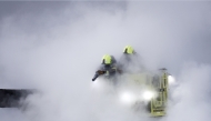 Firefighters douses flames of a fire that broke out at a substation supplying power to Heathrow Airport in Hayes, west London on March 21, 2025. (Photo by Benjamin Cremel / AFP)
