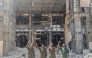 Soldiers of the Sudanese army or affiliated forces pose for a picture while pumping their fists at the damaged presidential palace after recapturing the complex from RSF paramilitaries in Khartoum on March 21, 2025. (Photo by AFP)