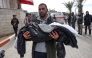 A Palestinian man carries the body of a child killed in an Israeli strike, in the yard of the Indonesian hospital in Beit Lahia in the northern Gaza Strip on March 22, 2025. (Photoby Bashar Taleb / AFP)