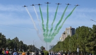 People watch as the Pakistan Air Force Karakoram-8 (K-8) aircraft team performs aerobatic manoeuvres during the national day parade as they fly past near the President's House in Islamabad on March 23, 2025. (Photo by Aamir QURESHI / AFP)
