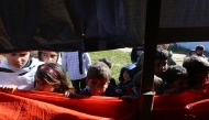 Palestinian children look into a tent as workers search through the rubble of a building at the site of an Israeli strike in Khan Yunis in the southern Gaza Strip on March 23, 2025. (Photo by AFP)
