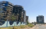 A vehicle moves along a road past (L) the heavily damaged building that housed the headquarters of the Central Bank of Sudan is pictured in Khartoum's Muqrin neighbourhood on March 22, 2025. (Photo by AFP)
