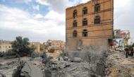 People gather by the rubble of a collapsed building at the site of a reported US air strike on Yemen's capital Sanaa on March 24, 2025. (Photo by Mohammed Huwais / AFP)
