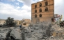 People gather by the rubble of a collapsed building at the site of a reported US air strike on Yemen's capital Sanaa on March 24, 2025. (Photo by Mohammed Huwais / AFP)
