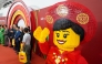 Attendees take photos past a full-scale model made with Lego bricks during the inauguration of the Lego factory in Binh Duong Province on April 9, 2025. Photo by Huu Khoa / AFP