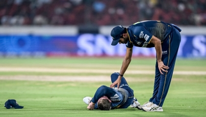 Gujarat Titans' Washington Sundar (R) checks on his teammate Glenn Phillips during the Indian Premier League (IPL) Twenty20 cricket match in Hyderabad on April 6, 2025. (Photo by Noah Seelam / AFP) 