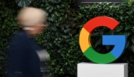 (Files) A woman walks past a Google logo at the Google Campus in Warsaw on February 13, 2025. (Photo by Sergei Gapon / AFP)