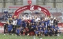 Al Sailiya's players and officials celebrate with the trophy.