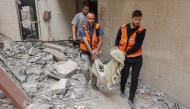 Palestinian medics transport the body of a victim following Israeli strikes which hit apartments in a residential building in Gaza City's Yarmuk street on April 24, 2025. Photo by Omar Al-Qattaa / AFP