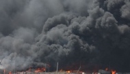 A handout picture provided by the Iranian Red Crescent (IRCS) on April 28, 2025, shows thick black smoke billowing at the scene of a massive explosion two days earlier at the Shahid Rajaee port dock southwest of Bandar Abbas in the Iranian province of Hormozgan. Photo by Iranian Red Crescent / AFP