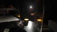 A waiter gives change by the light of her phone in a bar during a massive power cut affecting the entire Iberian peninsula and the south of France, in Hernani on April 28, 2025. (Photo by ANDER GILLENEA / AFP)
