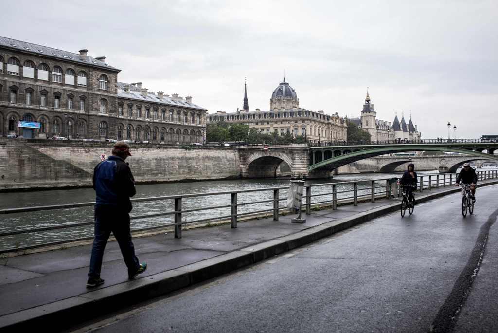 A man walks on the banks of the River Seine during 