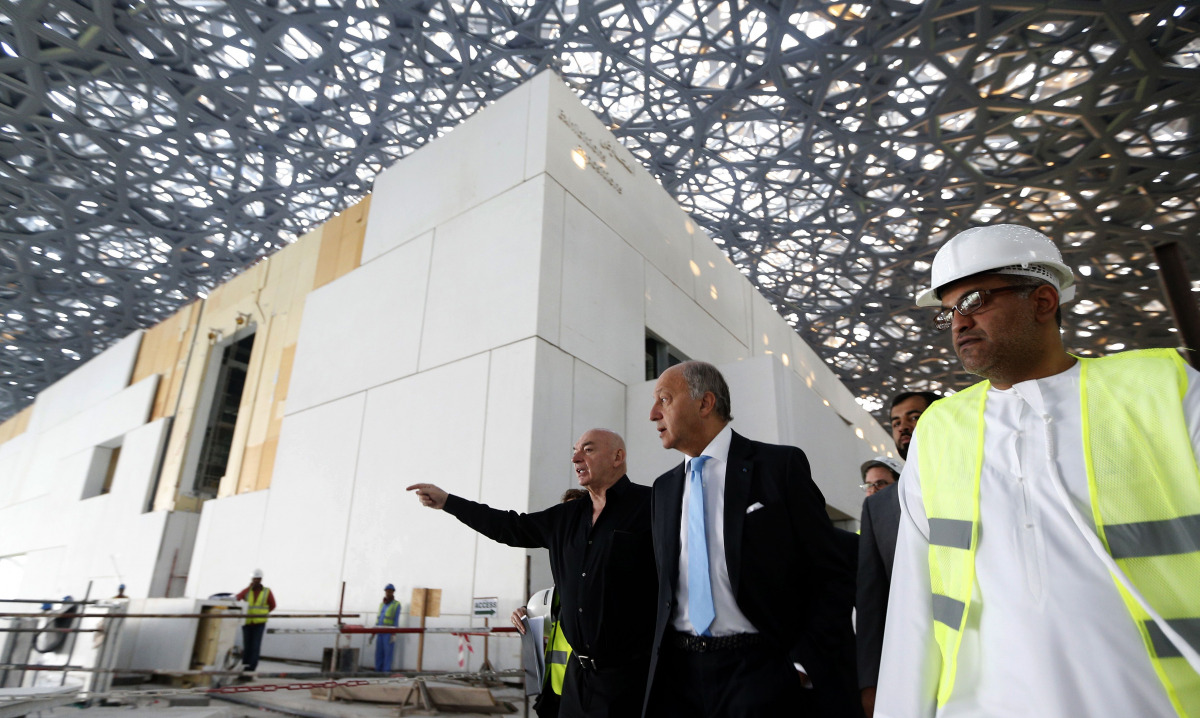 This file photo taken on January 18, 2016 shows French Foreign Minister Laurent Fabius (C) and French architect Jean Nouvel (L) visiting the construction site of the future Louvre museum on Saadiyat island, outside the UAE capital Abu Dhabi on January 18,