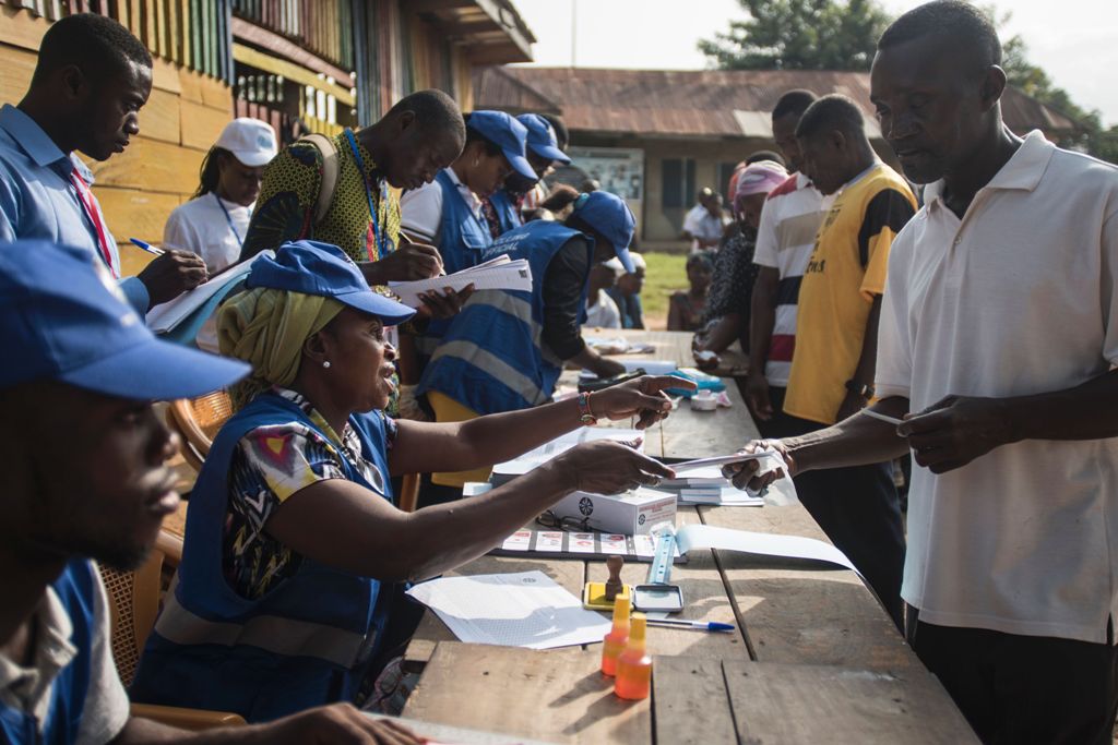 Electoral officers explain how to vote for the presidential election at a polling station in Kibi, southern Ghana, on December 7, 2016. Ghanaians cast their ballots in neck and neck presidential and parliamentary polls held at a time of economic woes and 