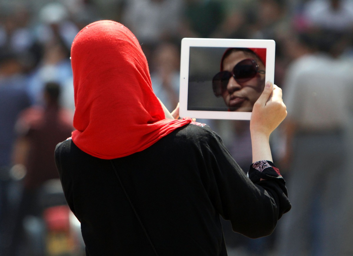 An Egyptian woman using her tablet to capture a video. (File photo / AFP / MOHAMMED ABED)