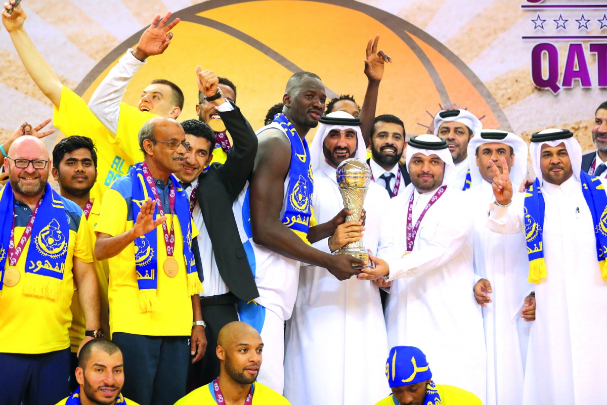 Al Gharafa basketball captain Omar Abdelkader Salem receiving the Qatar Cup at Al Gharafa Indoor Hall yesterday. Al Gharafa defeated defending champion Al Rayyan
104-91 in the final. Pic: Mohd Faraj  ? See also page 16