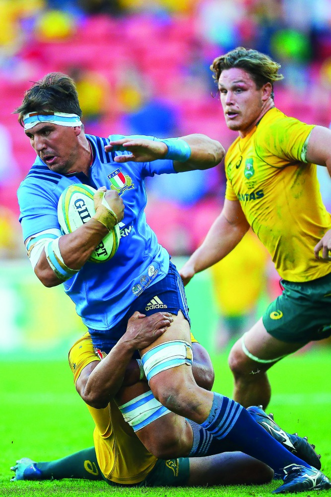 Andries Van Schalkwyk (left) of Italy is tackled by Lopeti Timani of Australia during their international rugby match at Suncorp Stadium in Brisbane, yesterday.