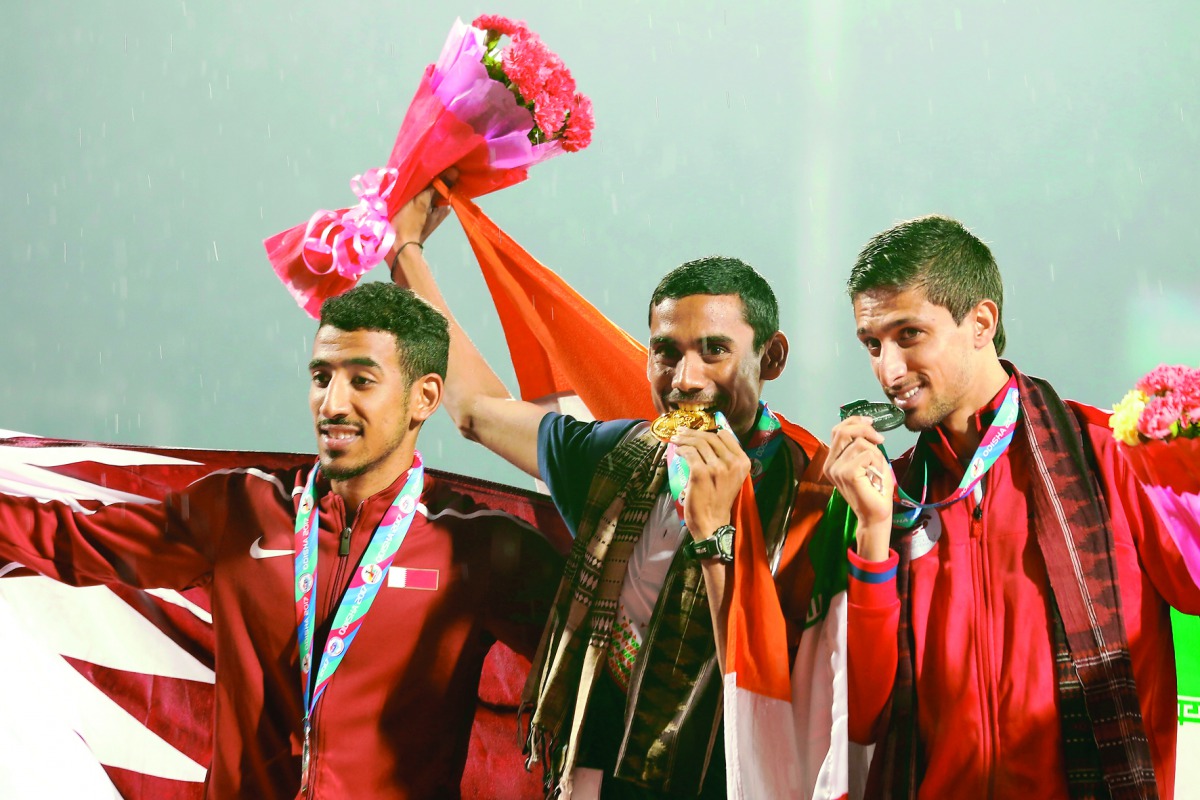 Qatar's Jamal Hairane (left) poses for a photograph with podium winners Ajay Kumar Saroj of India and Moslem Niadoost of Iran after the men's 1500m medal ceremony at the Kalinga Stadium in Bhubaneshwar, Odisha.