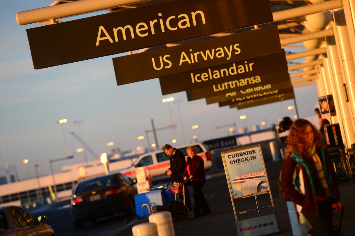 This December 9 2013 photo shows American Airlines and US Airways signs stand next to each others at Denver International Airport Colorado (AFP / Emmanuel Dunand) 