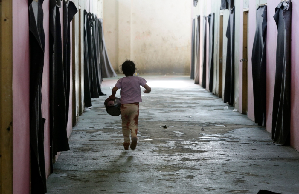 A displaced Syrian child runs at a government-run shelter after they were evacuated by the army from areas in the Eastern Ghouta region recently recaptured from rebels by government forces, on March 12, 2018 in Ad Duwayr on outskirts of Damascus. Syrian g