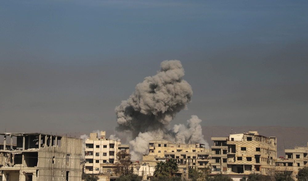 A general view shows smoke billowing in Hazeh, in the rebel enclave of Eastern Ghouta on the outskirts of Damascus on March 15, 2018 during reported shelling by Syrian government forces.  AFP / AMER ALMOHIBANY
