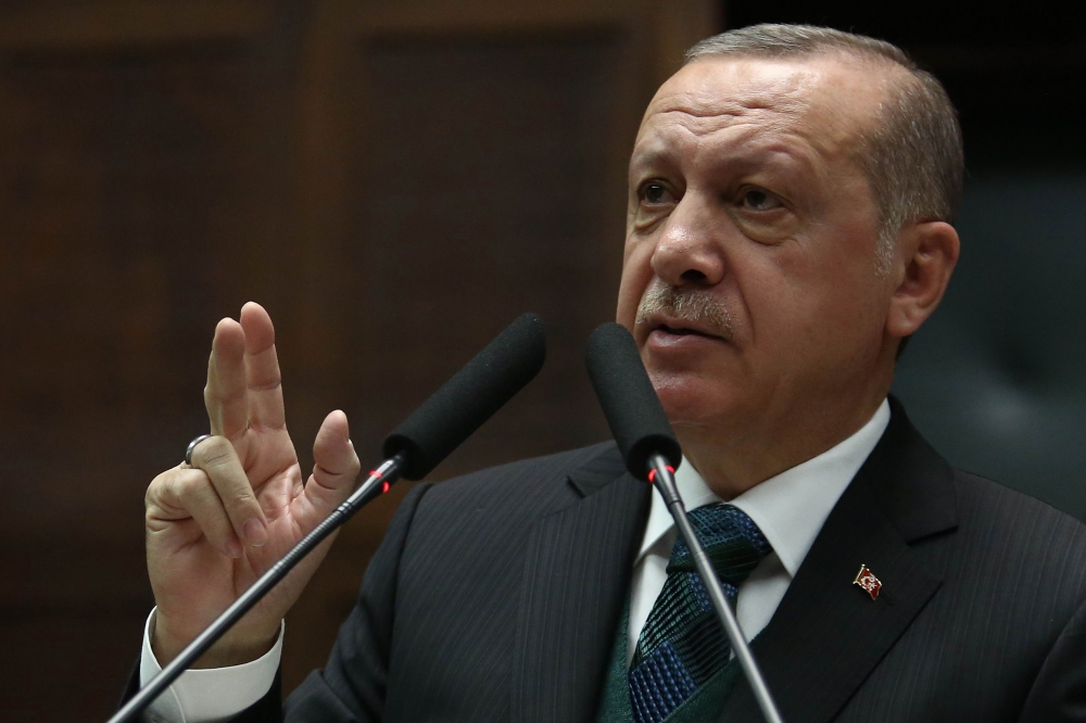 Turkish President and leader of the Justice and Development Party (AK Party) Recep Tayyip Erdogan gestures as he delivers a speech during the AK Party's parliamentary group meeting at the Grand National Assembly of Turkey (TBMM) in Ankara on March 20, 201