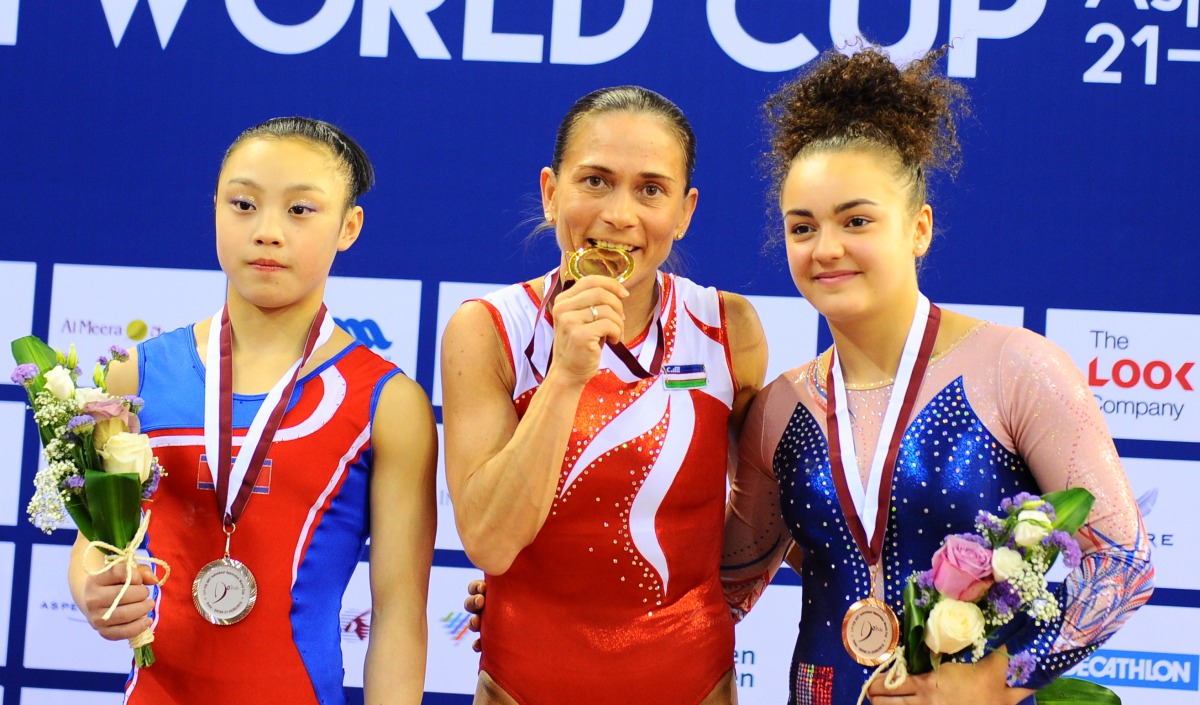 The podium winners of the Women’s Vault , champion Oksana Chusovitana of Uzbekistan (centre), silver medallist Pyon Rye Yong of North Korea (left) and bronze winner Coline Devillard of France pose for a photograph during the presentation ceremony yesterda