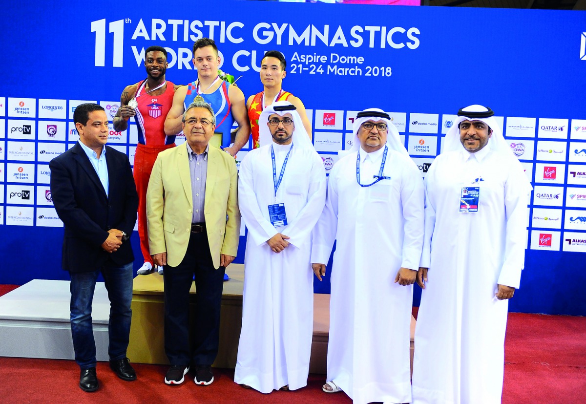 Podium winners of the Men’s Horizontal Bars, Tin Srbic (CRO), Marvin Kimble (USA) and Deng Shudi (CHN) pose for a photograph with officials during the presentation ceremony at the Aspire Dome yesterday. Pictures: Wasfi Aboushoush