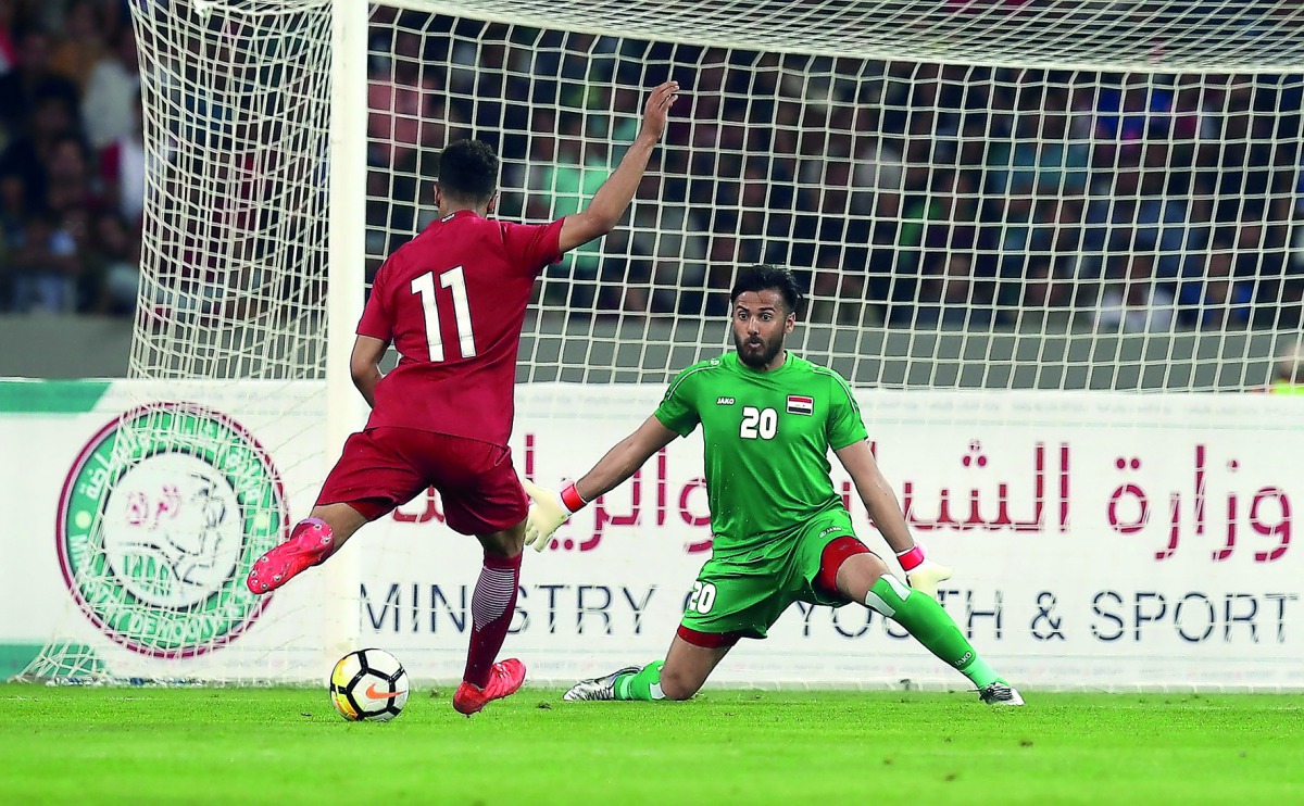 Qatar’s forward Akram Hassan Afif (left) prepares to shoot at the goal as Iraq’s goalkeeper Mohammed Hameed Farhan prepares to block during their Tri-nation International Friendly Tournament match at Basra Sports City Stadium yesterday.