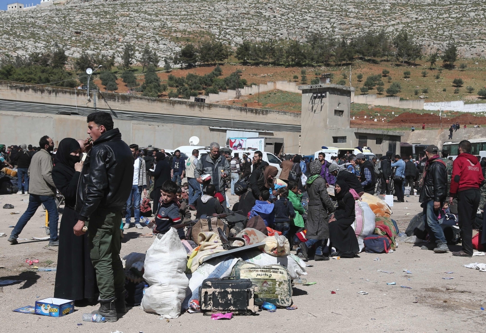 Syrian civilians and rebel fighters evacuated from Eastern Ghouta arrive in the village of Qalaat al-Madiq, some 45 kilometres northwest of the central city of Hama, on March 26, 2018, as evacuations from Eastern Ghouta continued following a deal that was