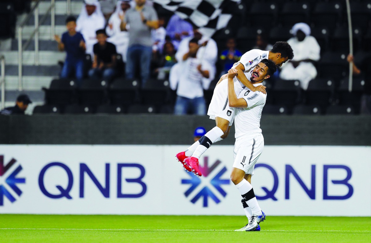 Al Sadd’s forward Baghdad Bounedjah (right) is congratulated by team-mate Akram Afif after scoring during the AFC Champions League football match  against UAE’s Al Wasl at the Jassim bin Hamad Stadium in Doha yesterday.