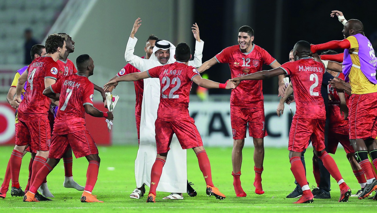 Al Duhail’s players celebrate with a team official after winning their AFC Champions League Round of 16 Second leg match against Al Ain at the Abudullah Bin Khalifa Stadium in Doha yesterday.