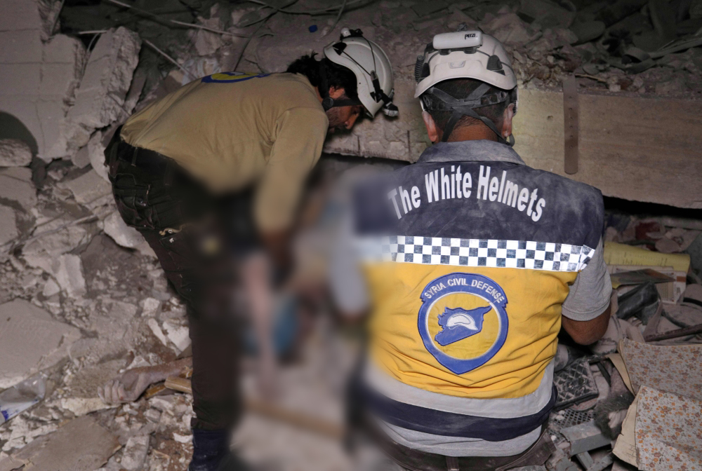 Syrian rescuers, known as White Helmets, recover bodies in Zardana, in the mostly rebel-held northern Syrian Idlib province, following air strikes in the area late on June 7, 2018.   AFP / OMAR HAJ KADOUR