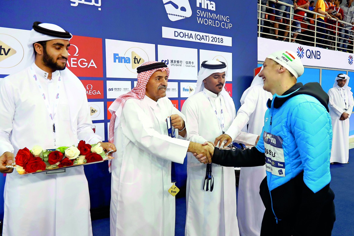 Qatar Olympic Committee Vice President Sheikh Saoud bin Ali Al Thani shakes hands with double gold medallist on the opening day of the FINA Swimming World Cup in Doha, Hungary’s Katinka Hosszu at the Hamad Aquatic Centre yesterday. 