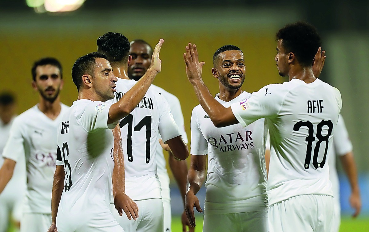 Al Sadd captain Xavi (left) and striker Akram Afif (right) celebrate along with their team-mates during their QSL match against Qatar SC at Qatar SC Stadium, yesterday. Pic: Mohammad Farag